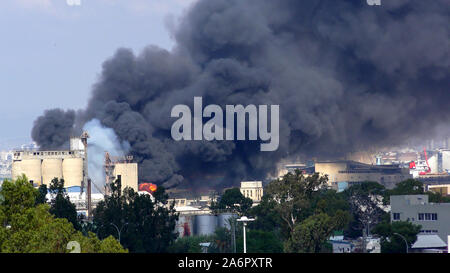 Fiamme di 80 tonnellate di olio da cucina a bruciare in fabbrica Shemen. Lo smog, fumo e cenere, inquinamento ecologico. Catastrofi industriali sono stati a lungo temuto dai residenti e il peggio deve ancora venire. Foto Stock