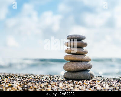 Equilibrio di pietre sulla spiaggia con copia spazio per il testo o il design. La piramide di pietre come zen, armonia, equilibrio concetto Foto Stock