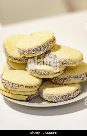 Accoppia e deliziosi biscotti argentini e uruguaiani alfajores con crema su carta primo piano sul tavolo. Orizzontale. Mate drink tradizionale in Uruguay Foto Stock