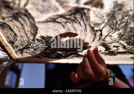 (191028) -- NANCHANG, 28 ottobre 2019 (Xinhua) -- Zhang Xiaohong ricama presso la sua officina in città Xinyu, Cina orientale della provincia di Jiangxi, Ottobre 23, 2019. Datato il Northern Song Dynasty (960-1127), Xiabu, o erba biancheria, è una sorta di panno fatto da ramiè. Zhang Xiaohong, 61 anni, è un rappresentante nazionale ereditiere del ricamo Xiabu. Nel 2002 ha istituito un laboratorio di ricamo nella sua città natale Xinyu dopo lo studio di Tianjin e Suzhou. Nel corso degli anni, Zhang aggiornato la qualità del tessuto e ha inoltre creato i sei modi di maglie. Nel 2014, essa è stata riconosciuta come la nazionale di r Foto Stock