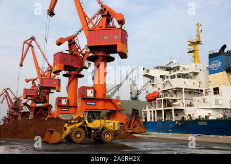 Grab gru a benna lungo una banchina di scarico del minerale di ferro da una massa di nave da carico al porto di Lianyungang Lianyungang in città, a est della Cina di Jiangsu Province su Octob Foto Stock