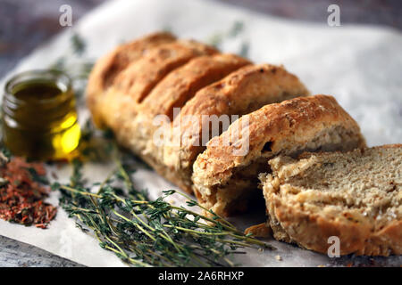 Freschi e deliziosi il pane fatto in casa. Pane italiano con erbe aromatiche. Messa a fuoco selettiva. Macro. Foto Stock