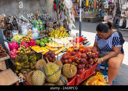 Ubud, Indonesia - 17 Settembre 2018: Donna vendita di varietà di frutta al mercato di Ubud. Foto Stock