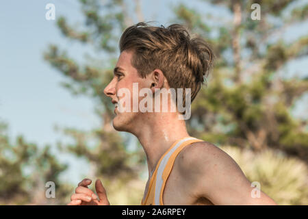 Close-up del Caucaso maschio teen cross country runner sudorazione in gara Foto Stock