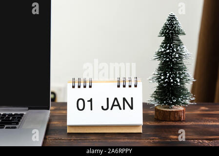 Nuovo Anno 01 Jan sulla scrivania in ufficio con computer portatile e albero di Natale Foto Stock