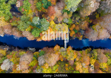 Killiecrankie, Perthshire, Scotland, Regno Unito. Il 28 ottobre 2019. Colori autunnali in alberi accanto al fiume Garry visto da un drone a Killiecrankie in Perthshire. Nella foto; passerella pedonale che attraversa il fiume Garry. Iain Masterton/Alamy Live News. Foto Stock