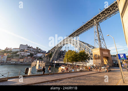 Oporto, Portogallo - Luglio 19, 2019: vista del ponte di Dom Luis I (costruito nel 1886) nel vecchio porto al tramonto Foto Stock