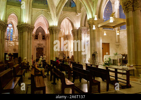 Persone in preghiera durante la messa nella Cripta della Sagrada Familia a Barcellona, Spagna Foto Stock