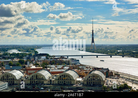 La torre della televisione e il fiume Daugava. In primo piano, Riga Mercato Centrale (Centraltirgus) convertito da hangar Zeppelin. Riga, Lettonia Foto Stock