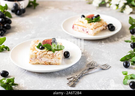 Pavlova su un biscotto con una delicata crema di cagliata, fichi e uva. Una nuova variante del classico dolce Australiano. Foto Stock