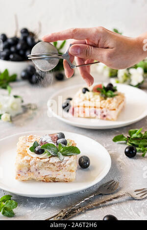 Pavlova su un biscotto con una delicata crema di cagliata, fichi e uva. Una nuova variante del classico dolce Australiano. Foto Stock