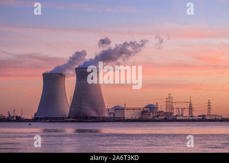 Riverbank con un impianto ad energia nucleare Doel durante un tramonto colorato, porto di Anversa, Belgio Foto Stock