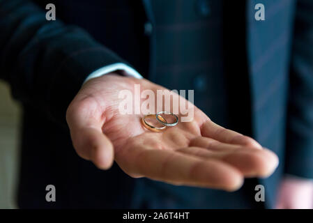 Miglior uomo tenendo gli anelli di nozze in aprire il palmo della mano sul giorno di nozze Foto Stock