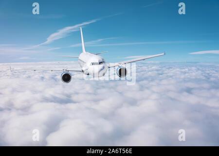 Aereo passeggeri vola sopra coperto in una giornata di sole Foto Stock