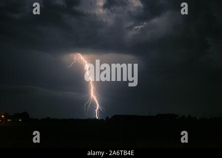 Ramificato brillante colpo di fulmine in prossimità di un montante di elettricità da un temporale nei Paesi Bassi Foto Stock