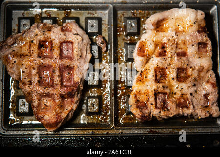 Barbecue per una festa, preparazione di cibo, in estate, pancetta scintillante, carne, caldo, prosciutto fritto, griglia elettrica, maiale fritto Foto Stock