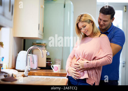 Uomo con il suo partner di gravidanza pancia Foto Stock