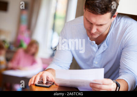 Uomo che guarda attraverso le sue fatture Foto Stock