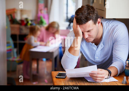 Uomo che guarda attraverso le sue fatture Foto Stock