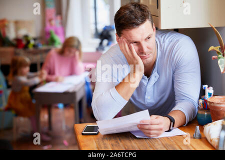 Uomo che guarda attraverso le sue fatture Foto Stock