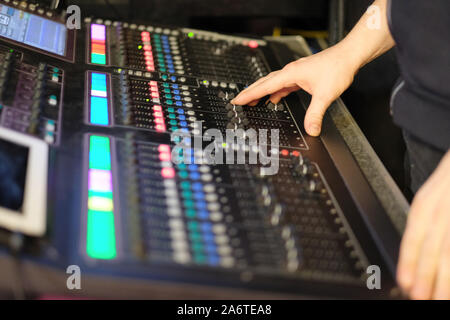 Il tecnico del suono al lavoro dietro una console di mixaggio in un concerto Foto Stock