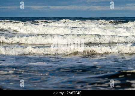 Heavy surf in rotolamento su una spiaggia del nord. Foto Stock