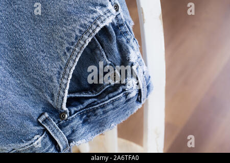 Sbiadito e indossato jeans sulla sedia Foto Stock