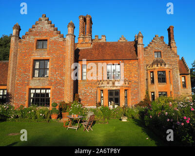 Chenies Manor House, delimitata dai confini dello stabilimento rifornito con dalie, Cosmos e piante erbacee, ad ovest di windows, su un bel pomeriggio. Foto Stock