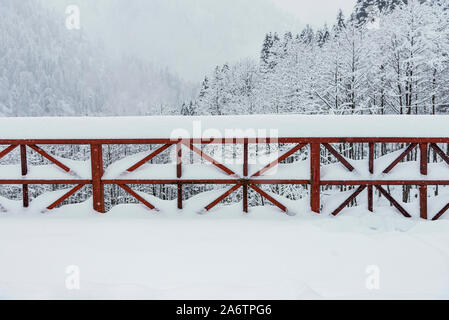 Colore rosso ringhiere su un ponte sotto la bufera di neve. Foto Stock