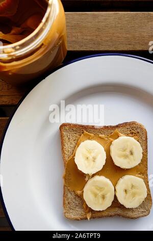 Fette di banana e burro di arachidi su Toast integrali Foto Stock