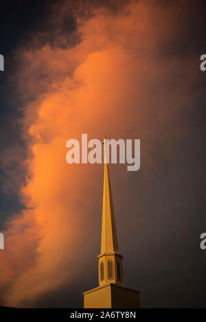 La chiesa il campanile e le nuvole sono illuminate dal sole di setting in North Central Florida. Foto Stock