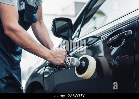 Vista parziale del detergente per auto auto lucidatura porta con macchina di buffer Foto Stock