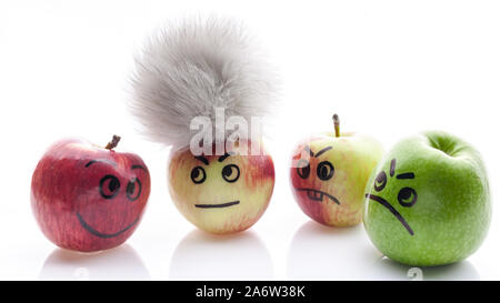 Volto dipinto mele. Jolly e triste mele divertenti. Verde e mele rosse su uno sfondo bianco. Foto Stock