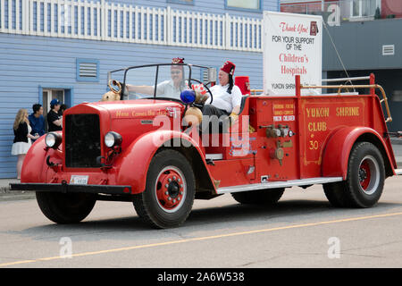 Shriner i membri del Club che guidare un antico camion dei pompieri durante il Canada giorno parata tenutasi il 01 luglio, 2019 in Whitehorse, Yukon Territory, Canada. Foto Stock