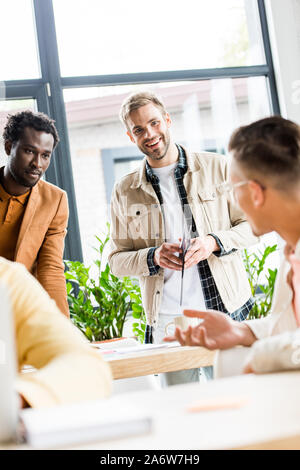 Messa a fuoco selettiva di imprenditori multiculturale per discutere progetti di avvio di office Foto Stock