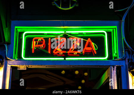 Insegna al neon per pizza di notte a Soho, London, Regno Unito (Pizza pellegrini) Foto Stock