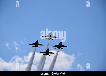 Una bassa angolazione di quattro jet da combattimento con grandi percorsi maneuvring nel cielo durante un air show Foto Stock