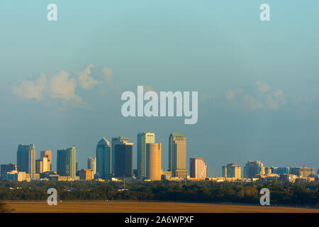 Piena Tampa Florida skyline che mostra la crescita di costruzione sul lato sud al tramonto con linea di albero e pulire il campo in primo piano Foto Stock