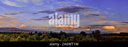 Panorama. Fairytale alba e tramonto con luminosi le nuvole colorate, su uno sfondo di colline ondulate Foto Stock