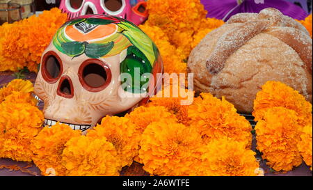 Cranio di zucchero, le calendule e pan de muerto in un giorno dei morti altare display (ofrenda) Foto Stock