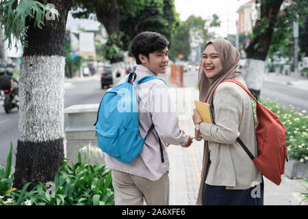Due studenti adolescenti sorridente a piedi mentre guardando indietro Foto Stock