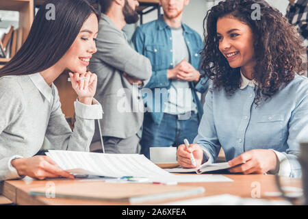 Startupers lavorando insieme a Office donna seduta al tavolo per discutere le note sorridente allegro Foto Stock