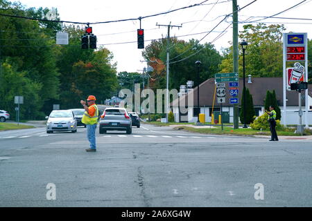 Storrs, CT, Stati Uniti d'America. 16 set 2019. Operaio edile aiutando membro trooper dirigere traffico nella zona di intersezione in fase di riparazione. Foto Stock