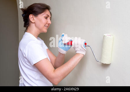 Donna dipinge la parete Foto Stock
