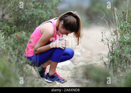 Sottolineato runner lamentando la sofferenza del ginocchio training ache all'aperto Foto Stock