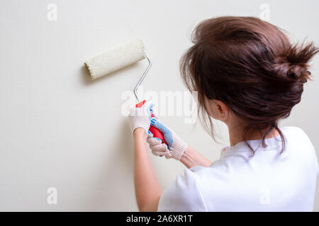 Ragazza dipinge la parete del rullo di vernice Foto Stock