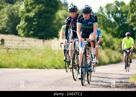 ROTHBURY, NEWCASTLE UPON TYNE, Regno Unito - Luglio 06, 2019: giovani ciclisti su un vicolo del paese a ciclone gara evento da Newcastle a Northumberlan Foto Stock