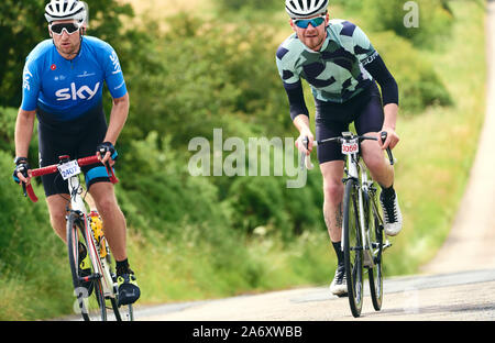 ROTHBURY, NEWCASTLE UPON TYNE, Regno Unito - Luglio 06, 2019: due giovani ciclisti a cavallo lungo un vicolo del paese a ciclone gara evento da Newcastle per Foto Stock