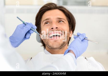 Ritratto di bello uomo sorridente frequentando il dentista Foto Stock