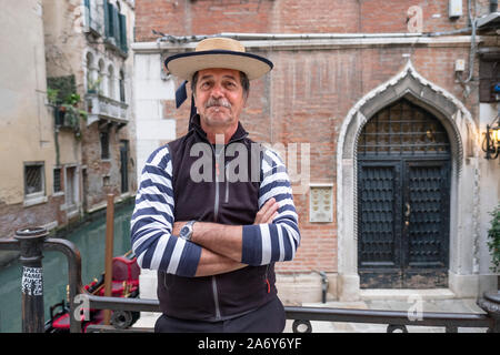 Poste ritratto di un gondoliere su una strada posteriore a Venezia, Italia. Foto Stock